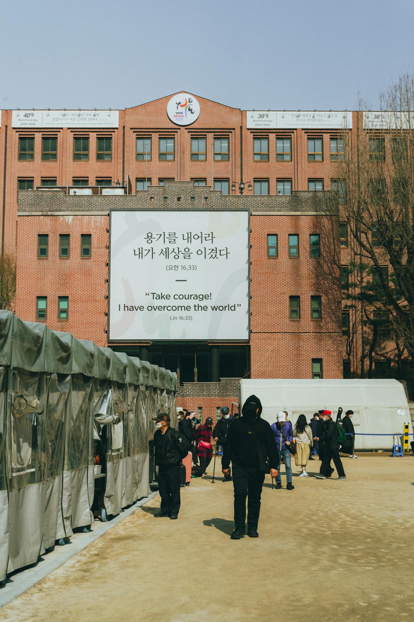 People gather near a building with a motivational sign in Seoul, South Korea.