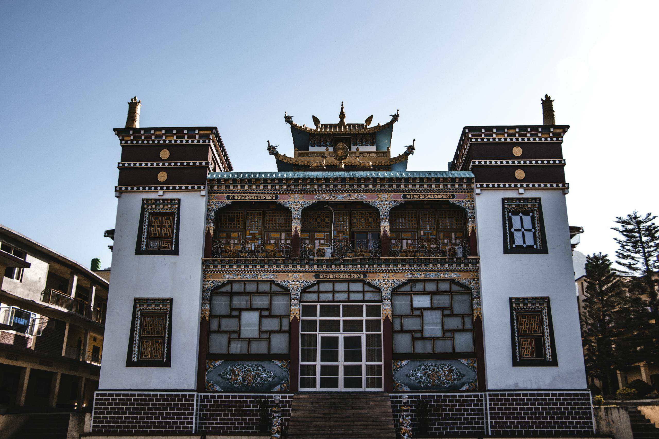 A vibrant Buddhist temple exterior showcasing traditional architecture under clear blue skies.
