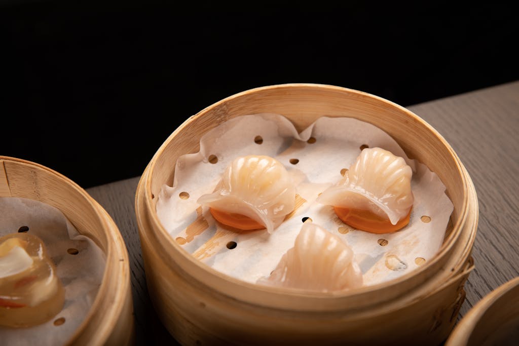 Close-up of steamed dim sum dumplings in a traditional bamboo basket, perfect for Asian cuisine themes.